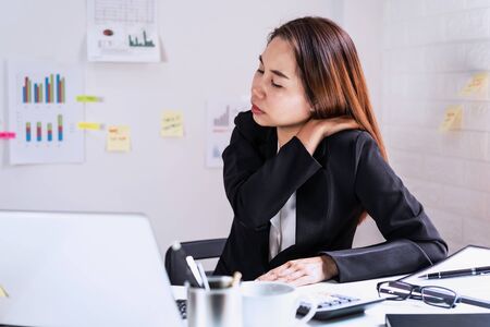 Stressed business woman suffering from shoulder and neck pain, Office syndrome conceptの写真素材