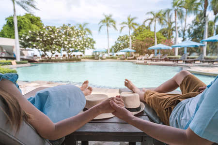 Young couple traveler enjoying a summer vacation at swimming pool in tropical resort near the beach, Travel lifestyle conceptの写真素材