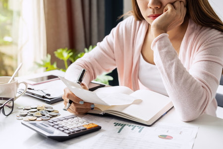 Stressed young woman calculating monthly home expenses, taxes, bank account balance and credit card...