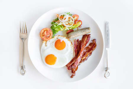 Top view of American breakfast with fork and knife on white backgroundの写真素材