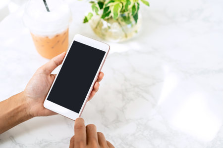 Young woman holding and using smart phone in coffe shop