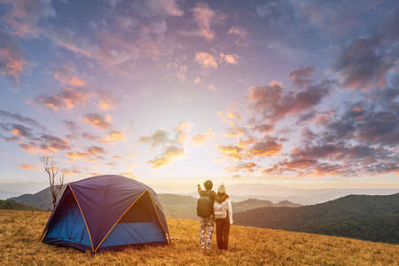 Young couple traveler looking landscape at sunset and camping on mountain, Adventure travel lifestyle conceptの写真素材