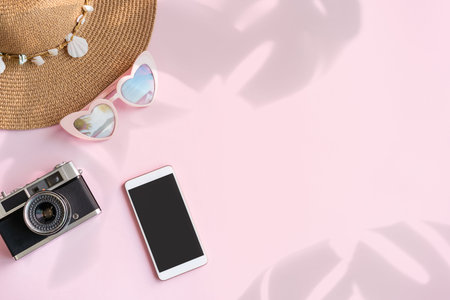 Travel accessories items with empty screen smart phone and retro camera on color background with...
