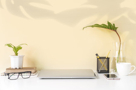 Modern and stylish workspace mock up with laptop and desk office supplies with color background and...
