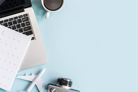 Computer with calendar and travel items on color background with copy space, Vacation planning...