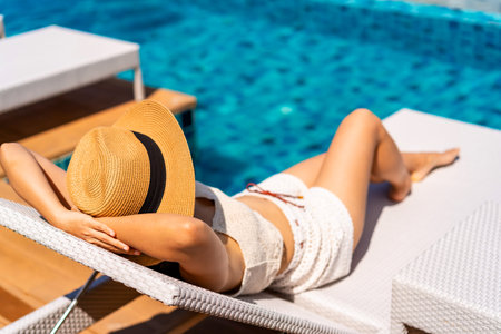 Young woman traveler relaxing at the resort pool while traveling for summer vacation