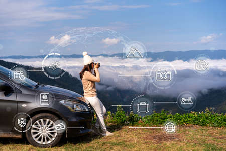 Young woman travelers with car watching a beautiful sea of fog over the mountain while travel driving road trip on vacation with travel icons diagram conceptの写真素材