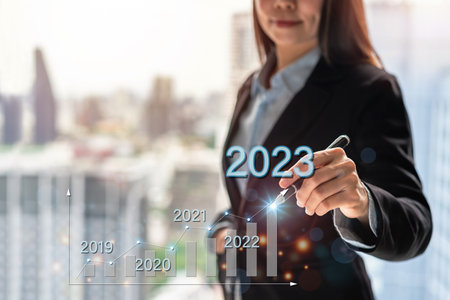 Businesswoman with a modern visual screen 2023 global network connection Graph analyzing financial growth and business planning conceptの写真素材