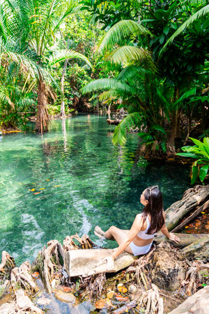 Young woman tourist relaxing and enjoying at klong nam sai in Krabi, Thailandの写真素材