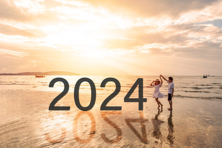 Young couple traveler looking beautiful sunset on the tranquil beach celebrating New Year 2024,...