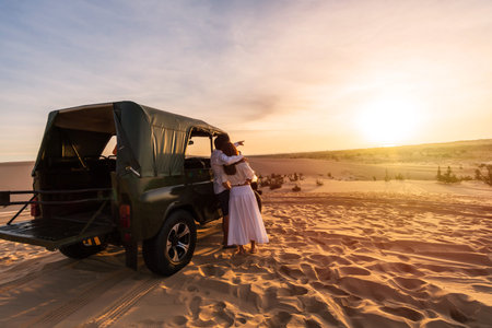 Young couple traveler enjoying the sunrise at white sand dunes in Vietnamの写真素材