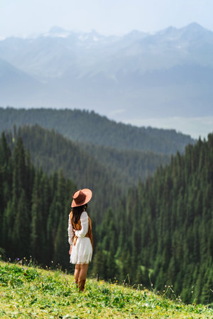 Young woman traveler relaxing and enjoying beautiful Scenery landscape with colorful flowers in Kalajun grassland of Xinjiang in summerの写真素材