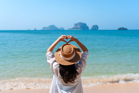 Young Asian woman relaxing and enjoying at beautiful white sand beach on sunny day, Travel on summer vacationの写真素材