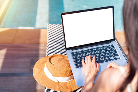 Young woman freelancer traveler working online using laptop while traveling for summer vacation, Workation and digital nomad conceptの写真素材