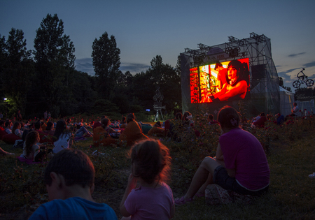 02 August 2018-Bucharest, Romania. People waiting and watching in the public park Herastrau for the movie to start on the projection screen of the open air cinemaのeditorial素材