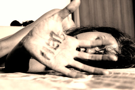 Concept of an abused woman with help written on her hand
