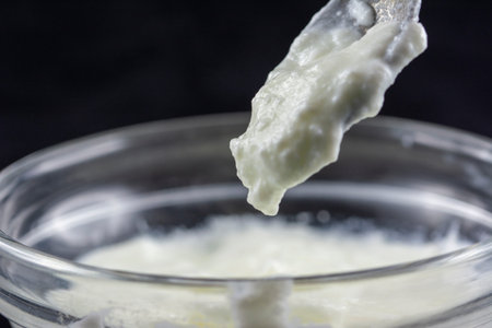 Macro on yoghurt falling off from the spoon