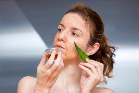 Female model applying and enjoying a diy, homemade mask treatment for dermatitis seborreica made of aloe vera, honey and cinnamon for its anti-inflammatory propertiesの写真素材