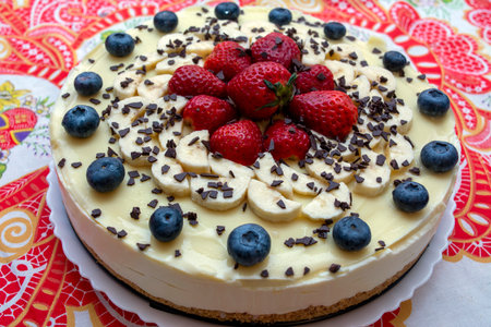 A delicious cheesecake with white chocolate, strawberries, blueberries and chocolate flakesの写真素材