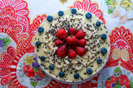 A delicious cheesecake with white chocolate, strawberries, blueberries and chocolate flakes