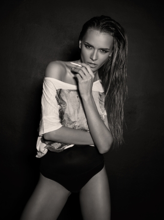 Black and whitephoto of beautiful young girl smoking a cigaretteの写真素材