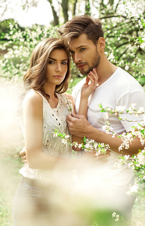 Portrait of beautiful couple in the blooming gardenの写真素材
