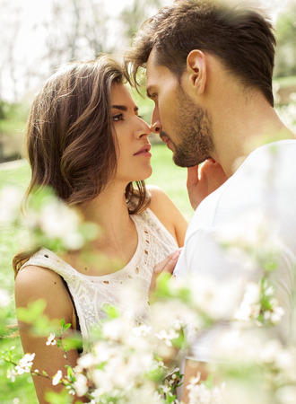 Portrait of kissing couple in the blooming gardenの写真素材