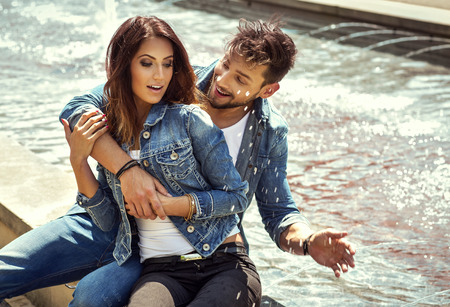 Happy man splashing the water on her girlfriend. Happy young couple in loveの写真素材