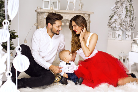Smiling parents looking each other in Christmas sceneryの写真素材