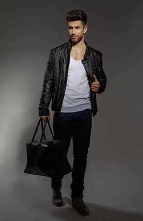 Handsome man wearing black leather jacket and bagの写真素材