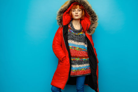 Woman in red jacket isolated on blue backgroundの写真素材