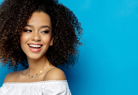 Portrait Of Beautiful Black Woman With Smiling Face Isolated On Blue Backgroundの写真素材
