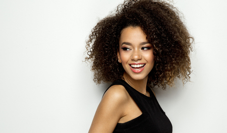 Portrait of young beautiful black woman smiling isolated on whiteの写真素材