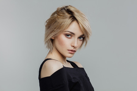 Portrait of blond beauty over grey backgroundの写真素材