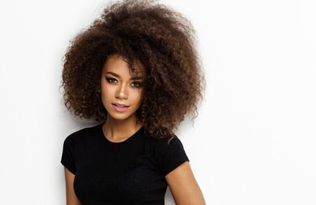 Portrait of young african american woman with afro looking at cameraの写真素材