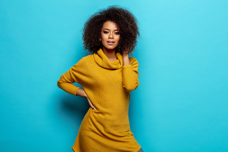Beautiful african american woman wear cardigan looking at cameraの写真素材