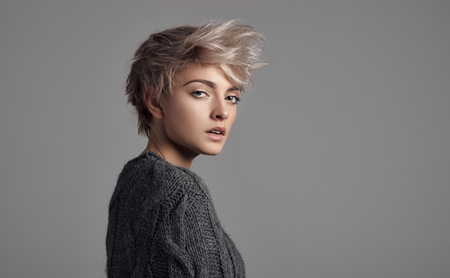 Fashion portrait of female model with blond short hair wear sweaterの写真素材
