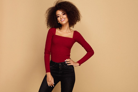 Beautiful african american woman with afro isolated on studio background with copy spaceの写真素材