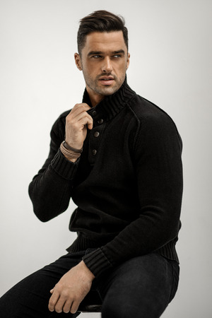 Handsome man in black wool turtleneck jumper isolated on white backgroundの写真素材