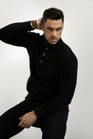 Handsome man in black wool turtleneck jumper isolated on white backgroundの写真素材