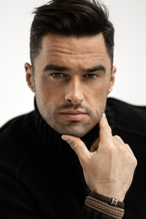 Portrait of handsome man in black turtleneck jumper isolated on white backgroundの写真素材
