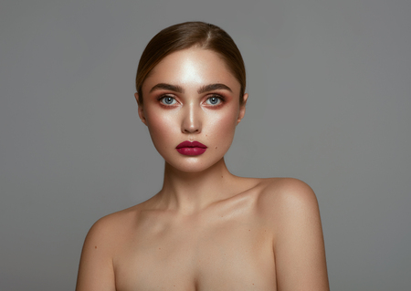 Beautiful face of young pretty girl with clean freash skin isolated over gray backgroundの写真素材