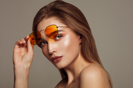 Close-up face of young girl with sunglasses isolated over gray backgroundの写真素材