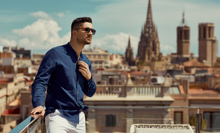 Portrait of handsome man wear sunglasses and standing against the background of the Barcelonaの写真素材