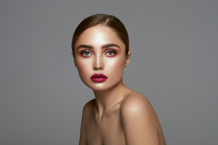 Beautiful face of young pretty girl with clean freash skin isolated over gray backgroundの写真素材