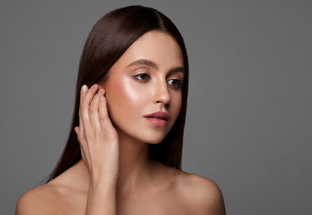 Beauty photo of young brunette woman touching earの写真素材