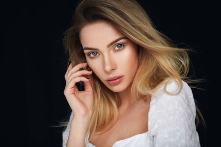 Portrait of sexy blonde woman looking at camera and  isolated on black backgroundの写真素材
