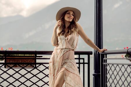 Fashionable woman in summer dress relaxing over mountain backgroundの写真素材