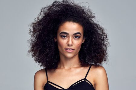 Portrait of beautiful latin american woman with afro hairstyle looking at cameraの写真素材