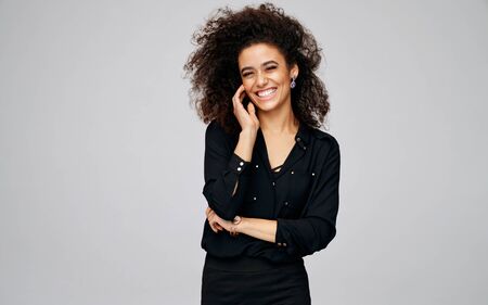 Portrait of cheerful african american woman with freckles and afro hairstyle isolated on gray backgroundの写真素材
